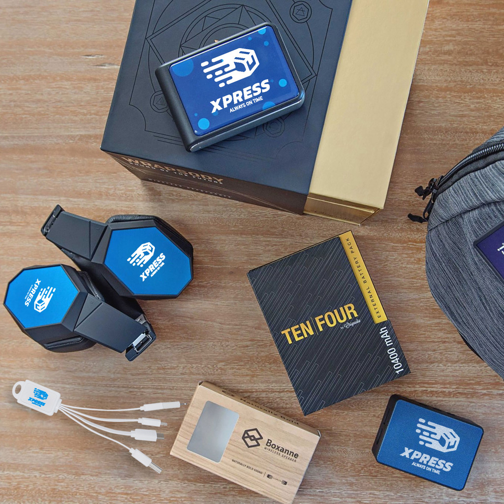 A flat lay of branded tech accessories, including headphones, power banks, and a wireless speaker, all featuring the blue Xpress 
